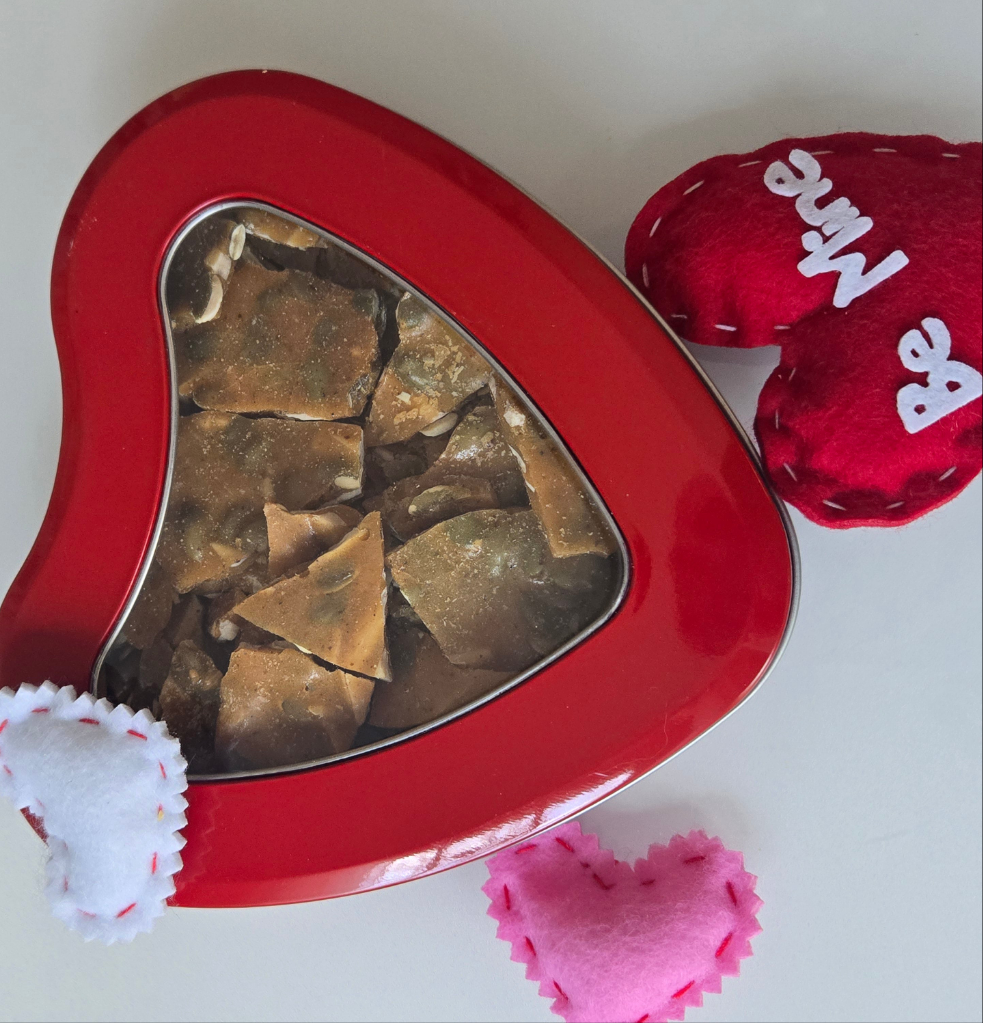 Closed red tin heart filled with brittle candy